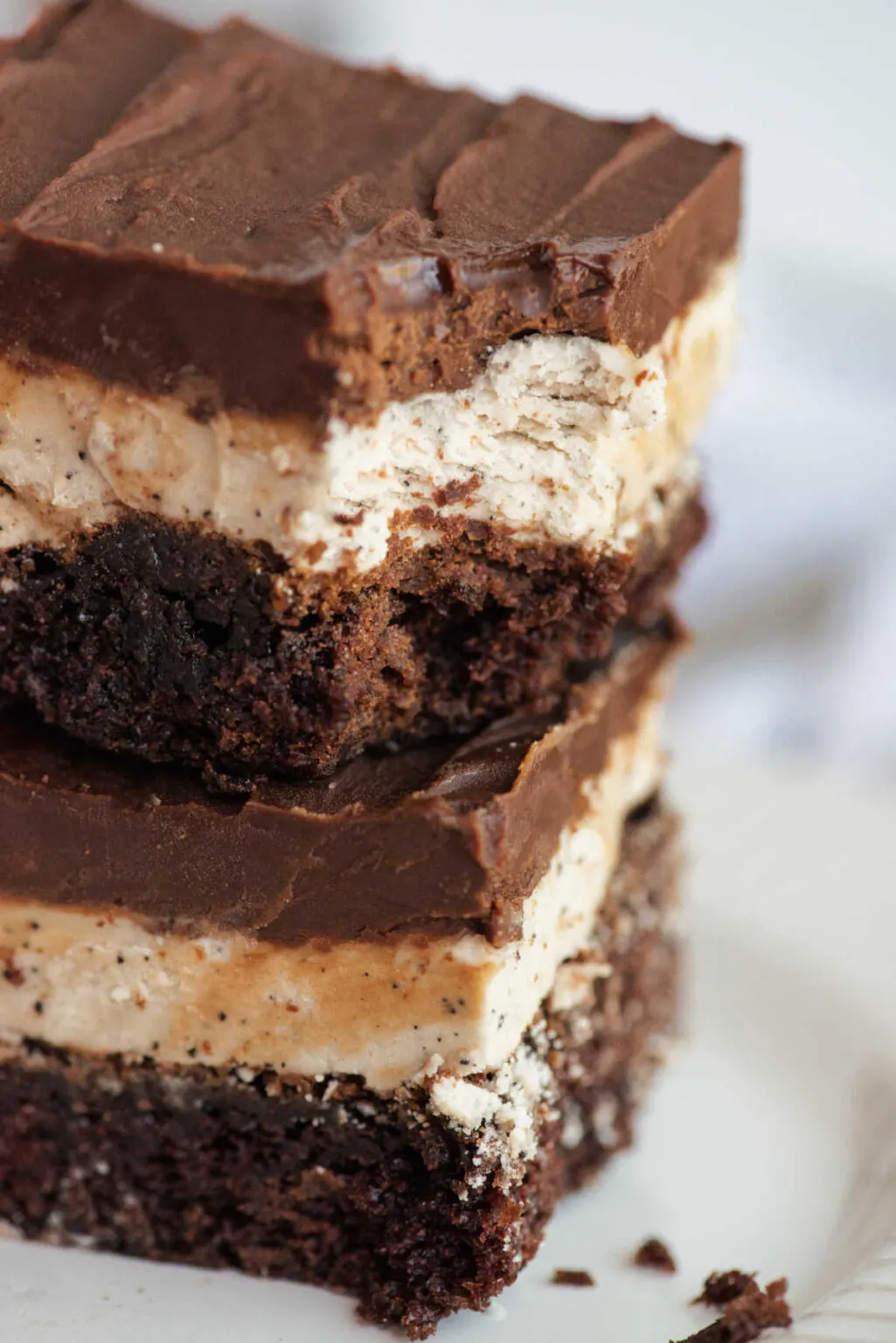 Triple layer chocolate brownies stacked atop one another.