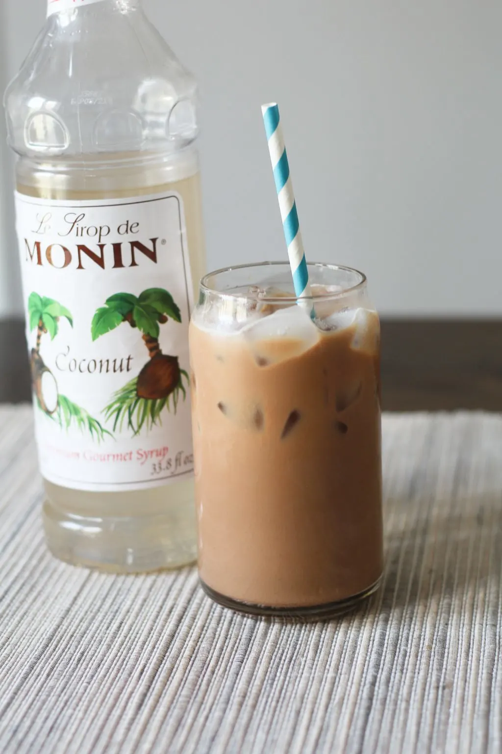 Coconut mocha iced coffee in a glass with a straw.