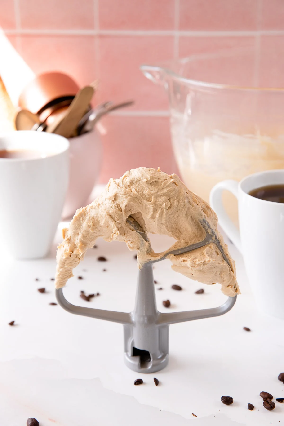 Coffee buttercream frosting on mixing attachment.