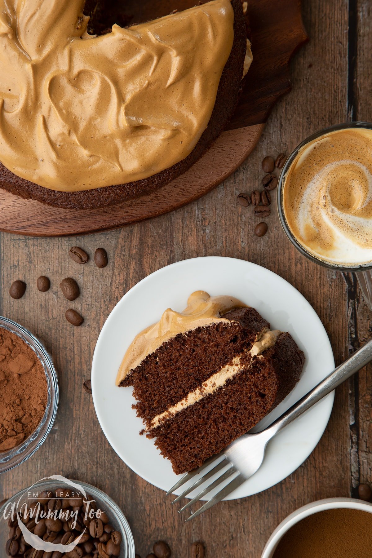 Dalgona chocolate cake slice on a white plate with more cake and ingredients in the background.