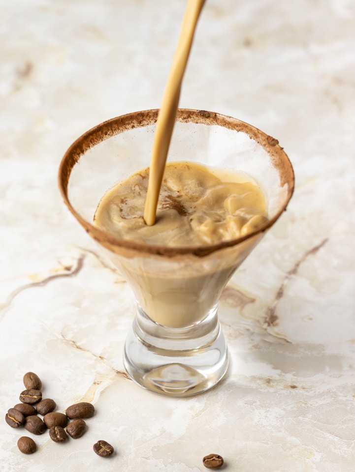 Espresso martini mocktail poured into cocoa powder rimmed martini glass.