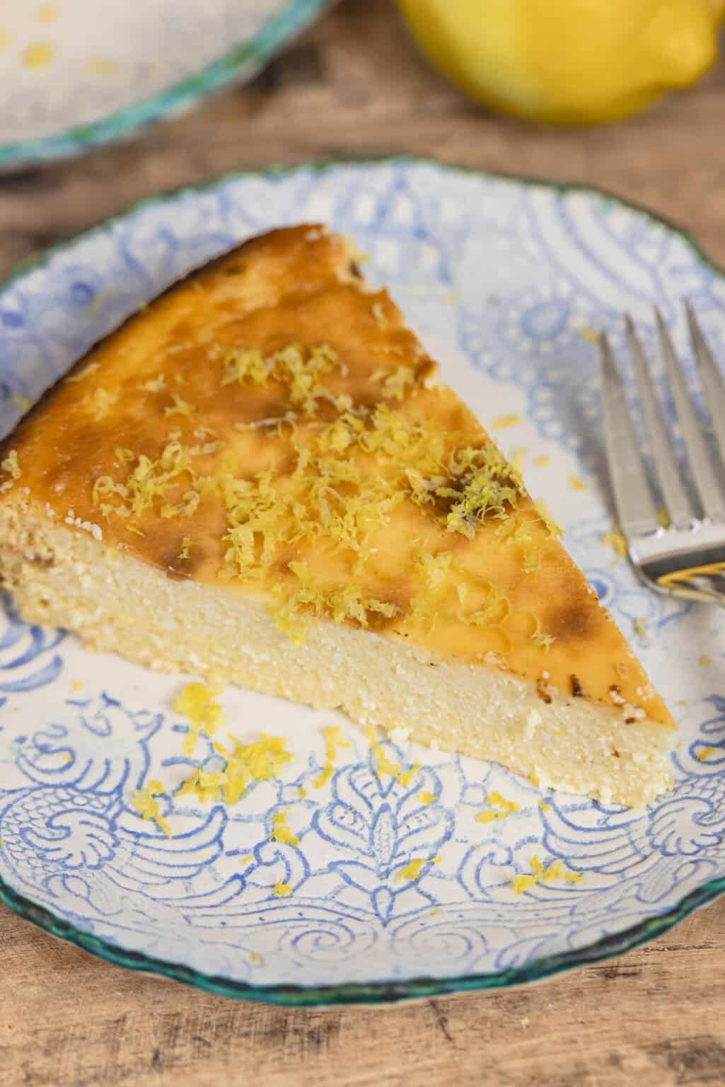 Lemon ricotta cheesecake slice on a decorative plate.
