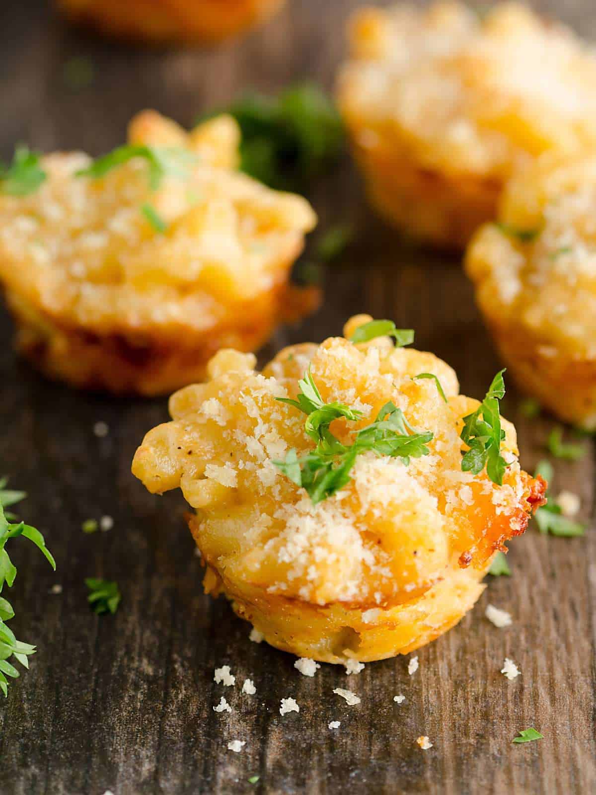 Lobster mac and cheese bites on a wooden background.