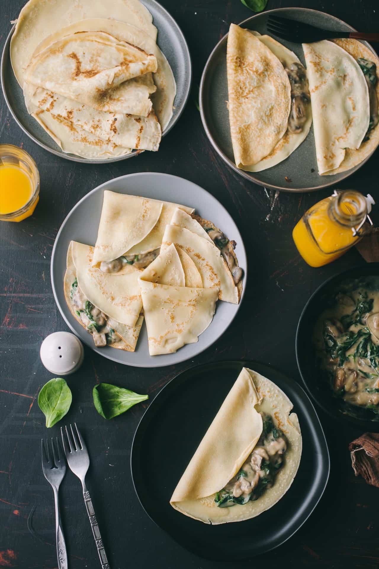 Mushroom and spinach crepes on plates.