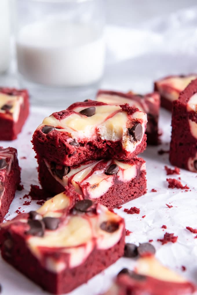 Red velvet cream cheese brownies on parchment paper.