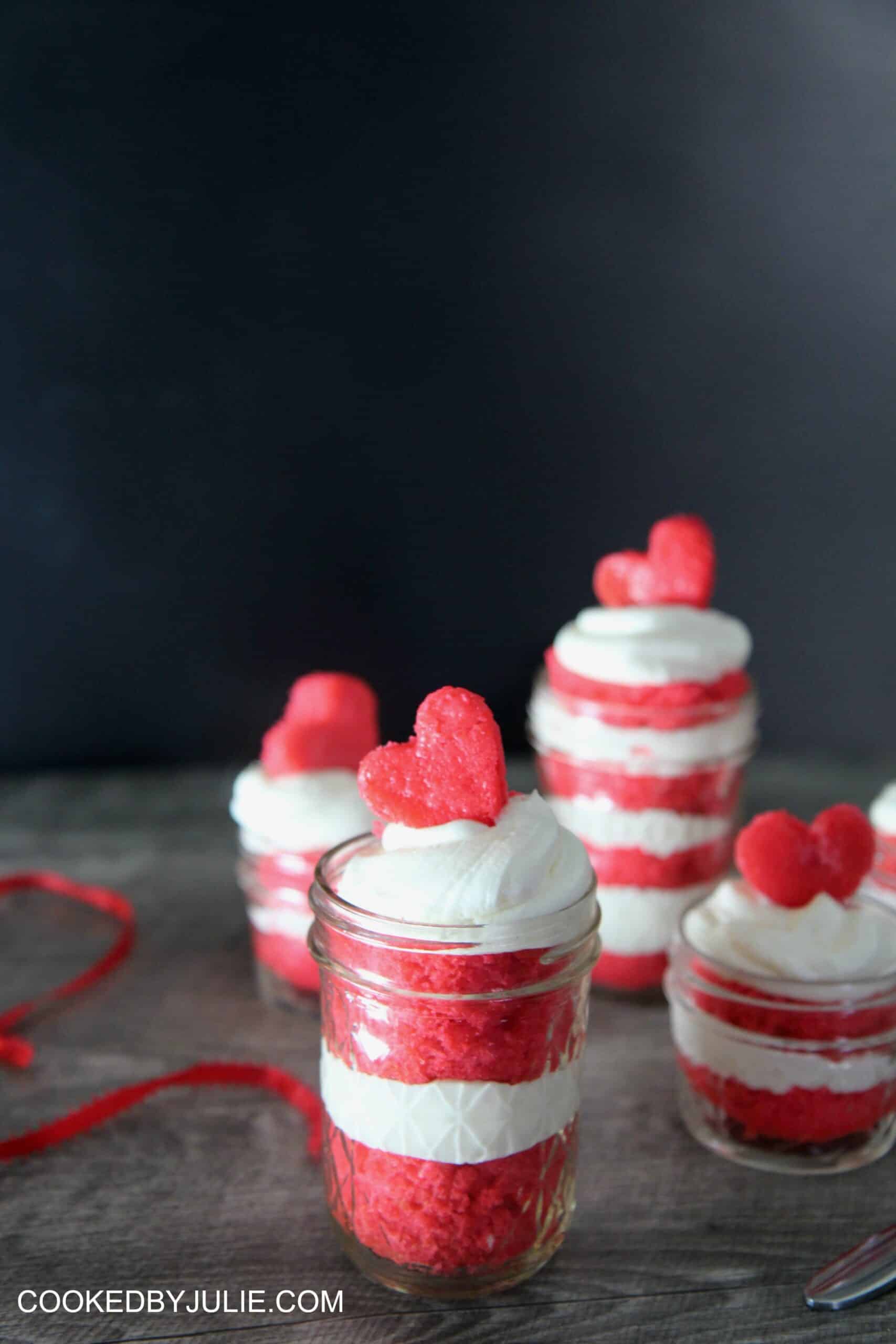 Red velvet cake jars with cake hearts on top.