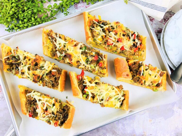 Baked Italian sausage baguette sliced on a serving tray.