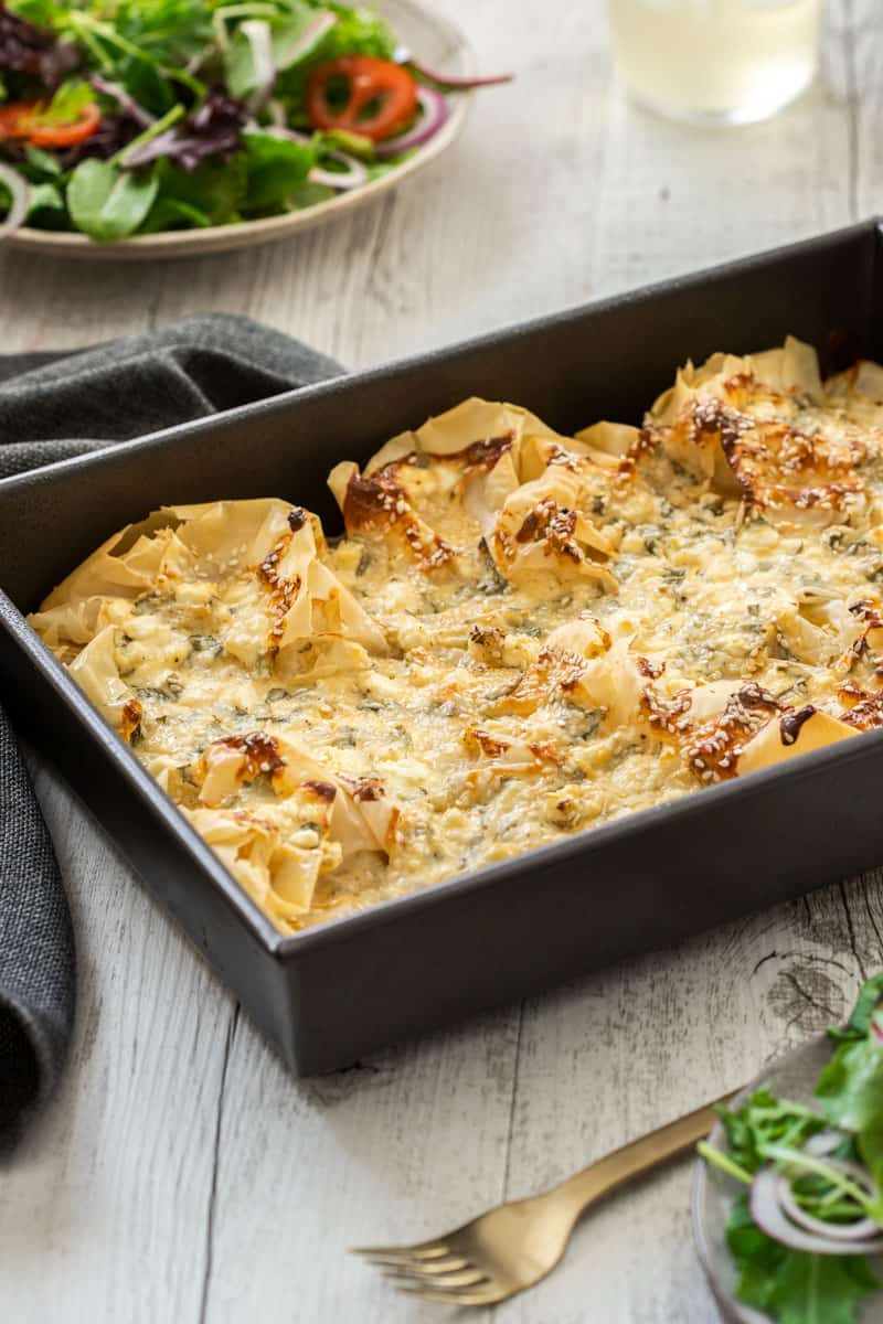 Cheese and herb filo pie in a baking pan.