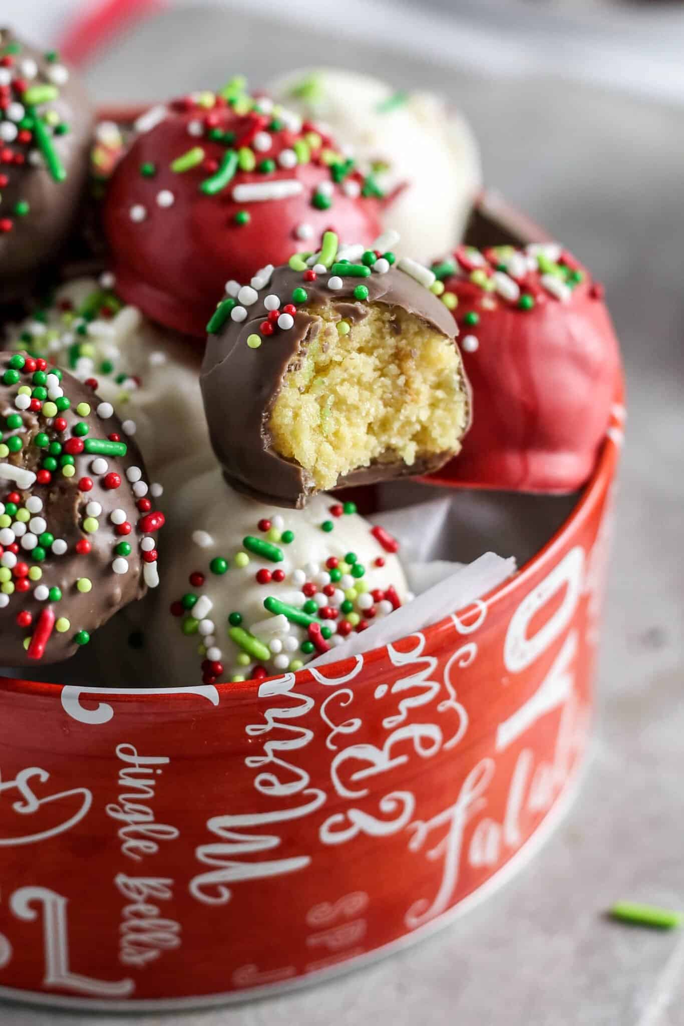 Moist Christmas cake balls in a tin container.