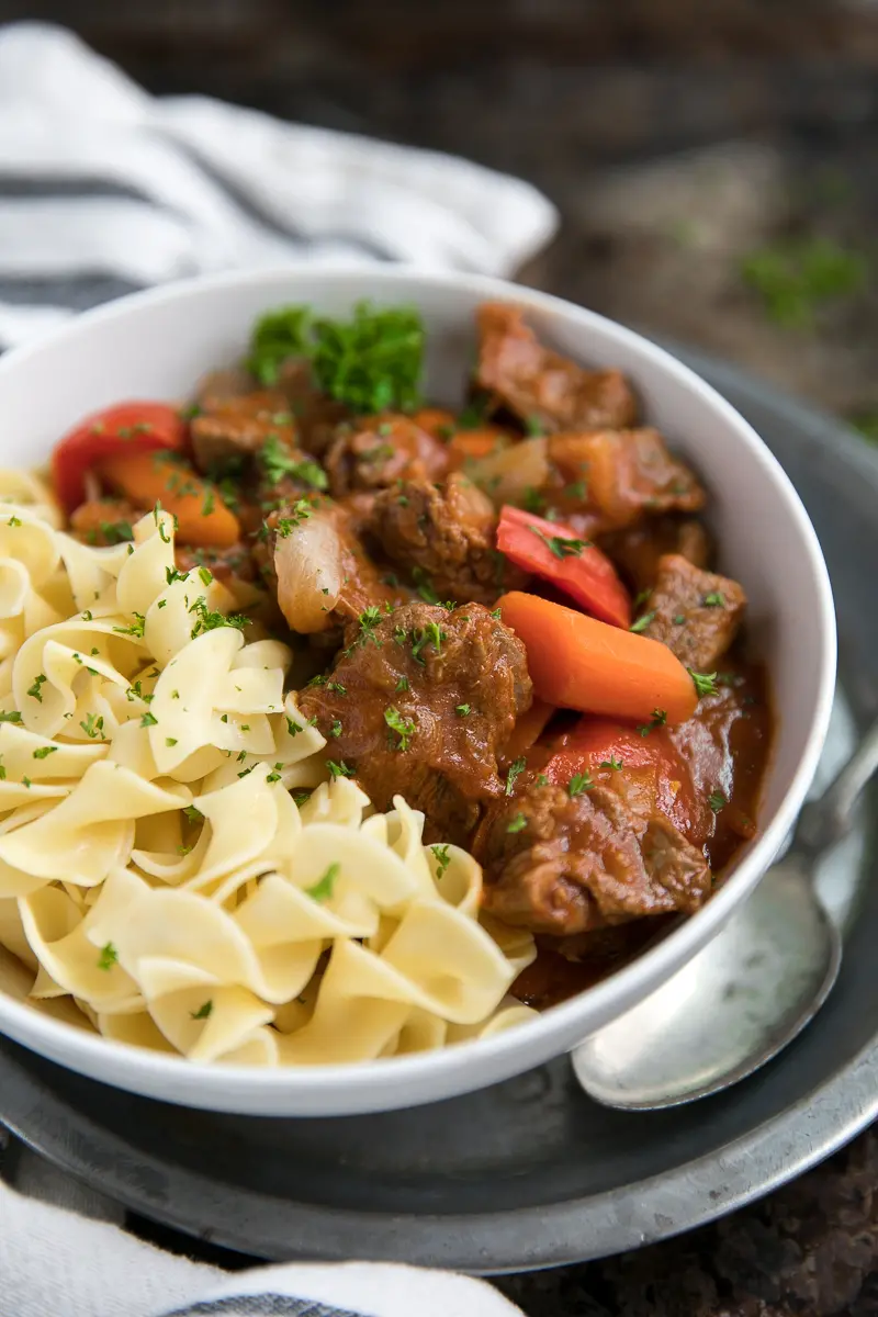 Hungarian Goulash with egg noodles in a white bowl.