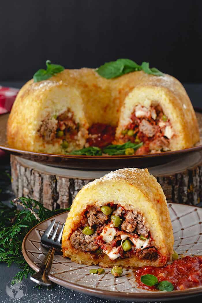 Neapolitan sausage meatballs and rice timbale in the shape of a bundt cake with slices removed.