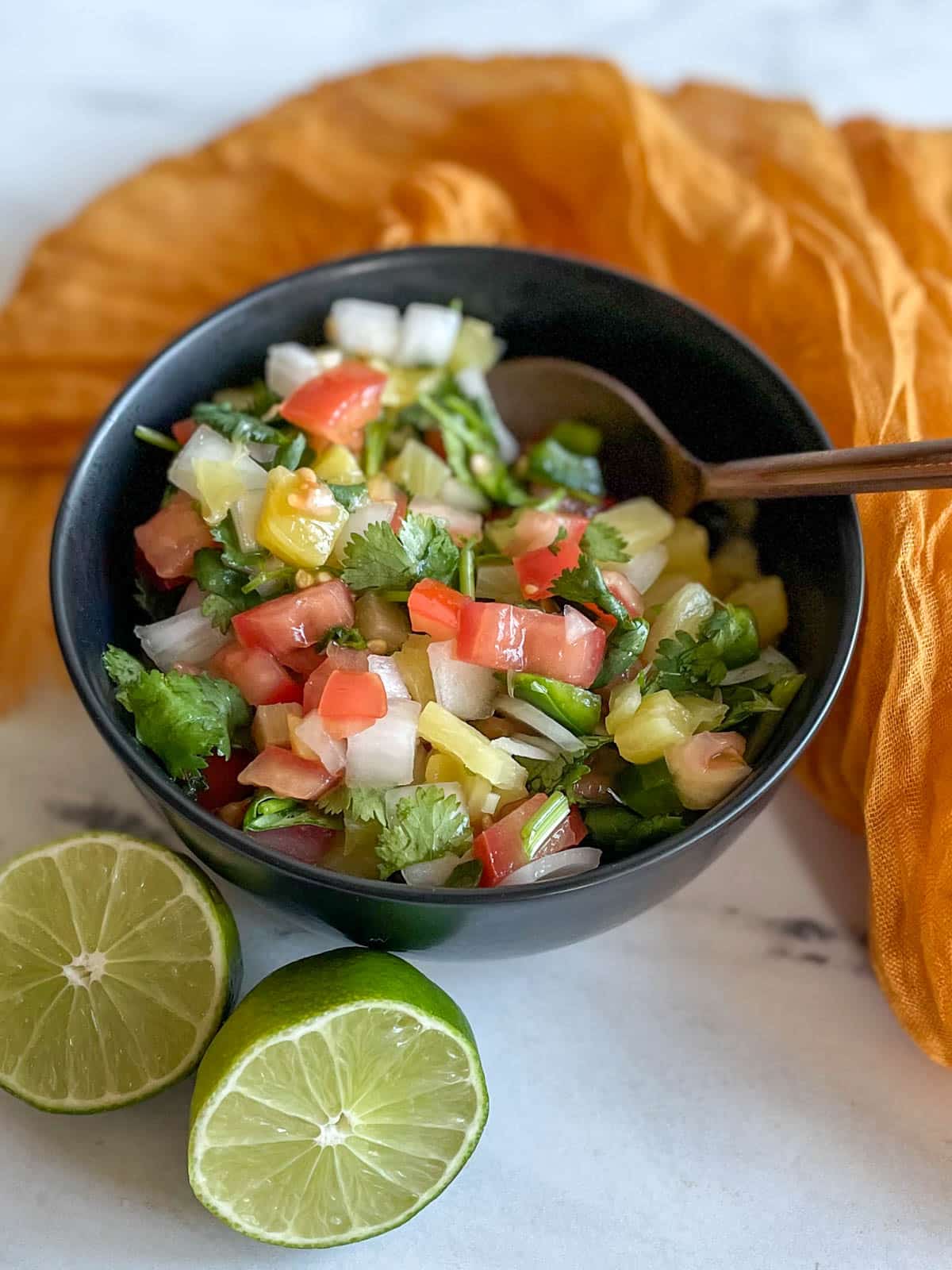 Pineapple pico de gallo in a bowl with spoon.