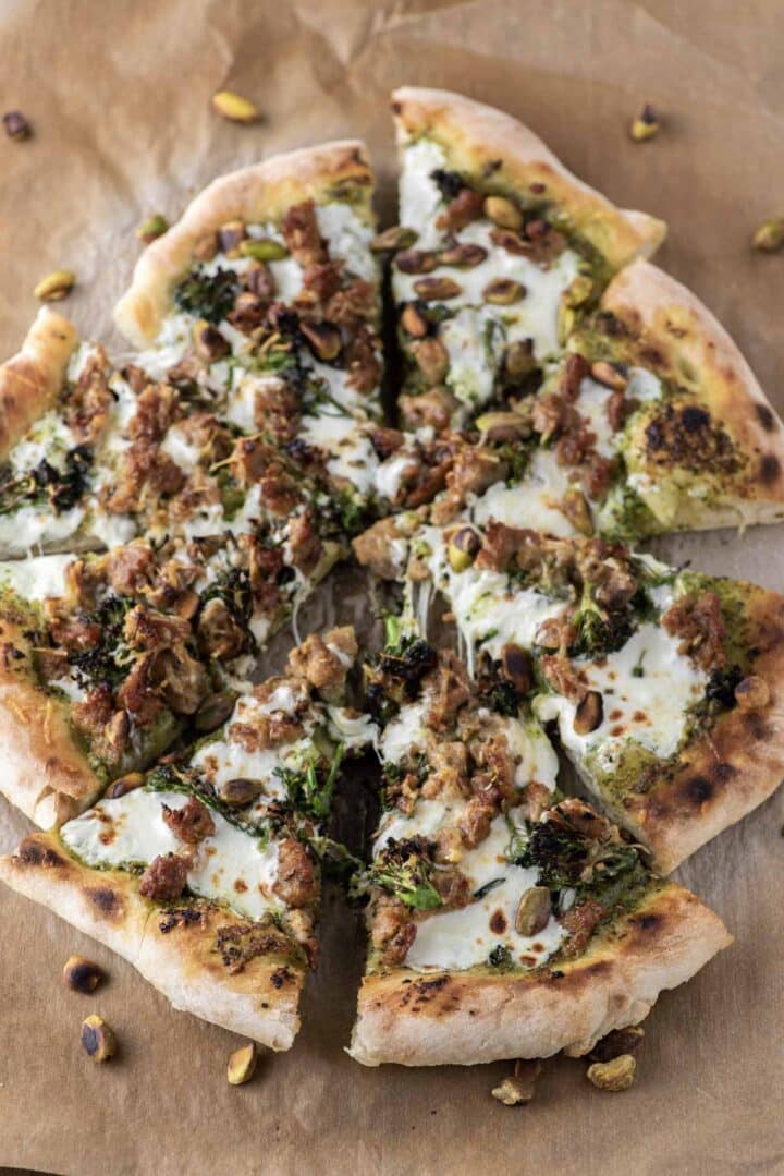 Sliced broccoli rabe pizza on parchment paper.