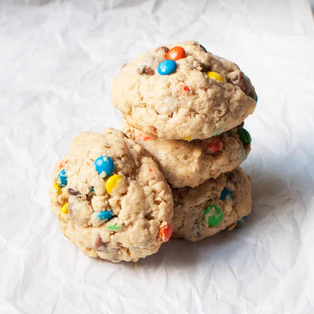 Stack of cake mix monster cookies on a crinkled parchment paper.