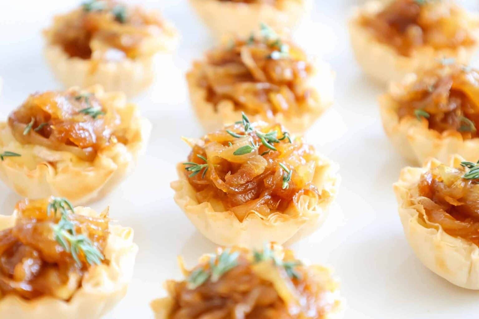 Phyllo cups stuffed with brie cheese and topped with caramelized onions and a sprinkle of a thyme.