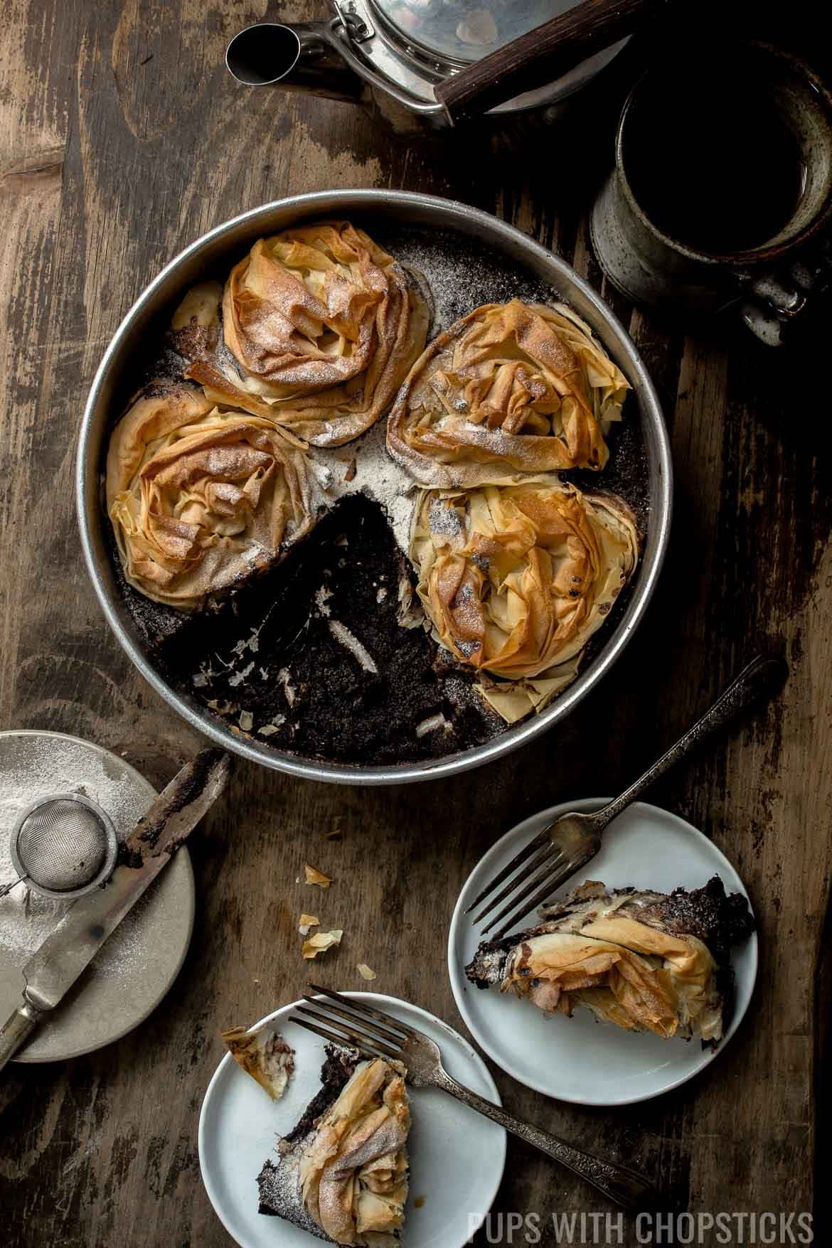 Black sesame chocolate ruffled milk pie in a baking pan with some served on white plates.