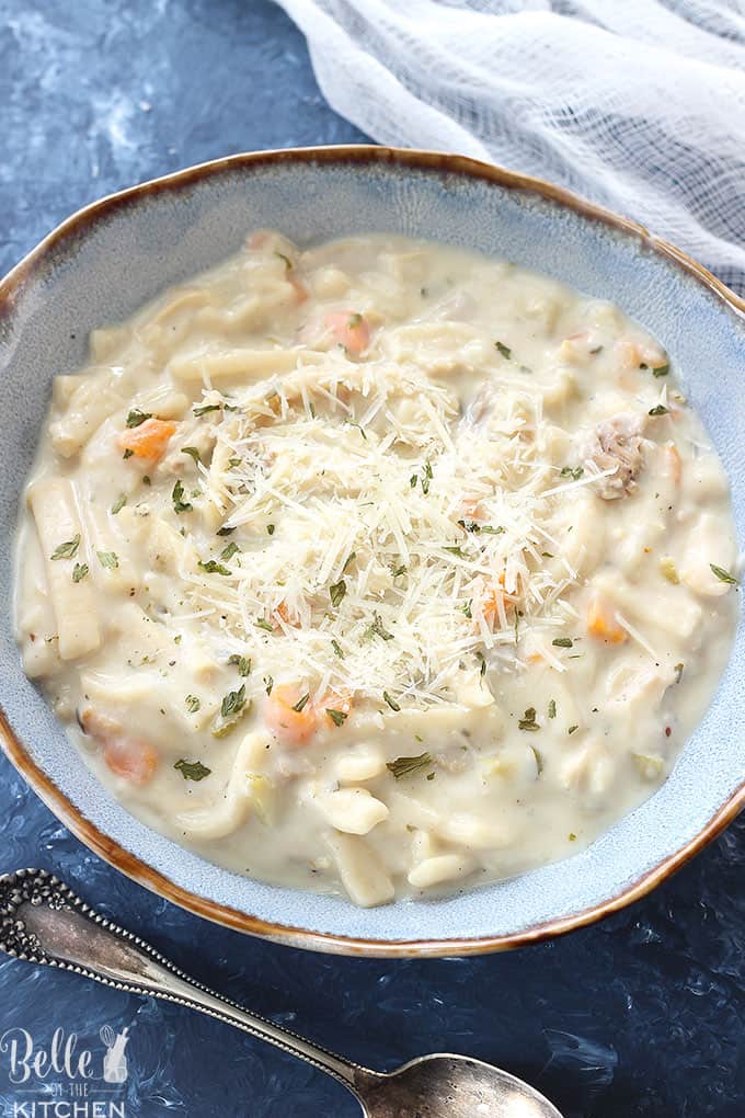 Bowl of creamy chicken noodle soup in a blue bowl.