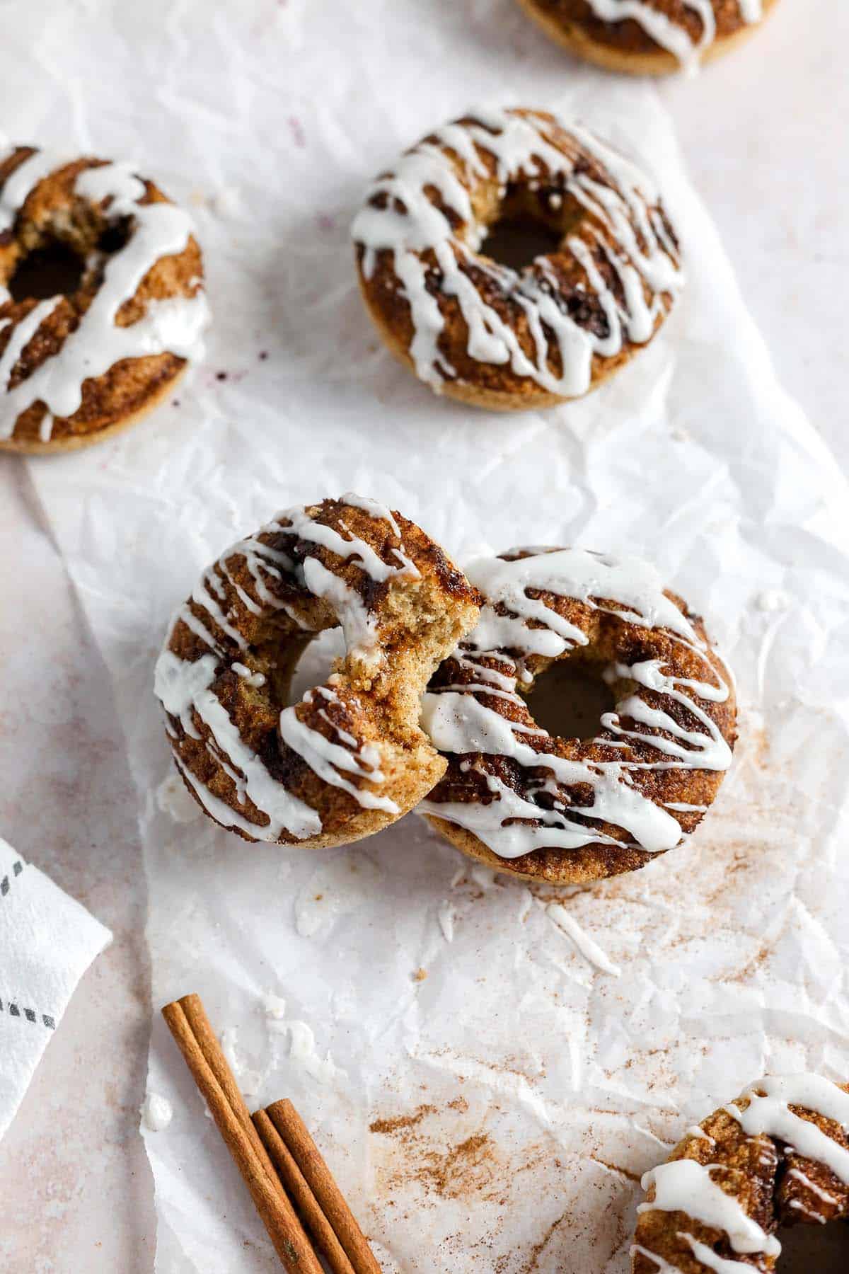 Cinnamon roll donuts on crinkled parchment paper.