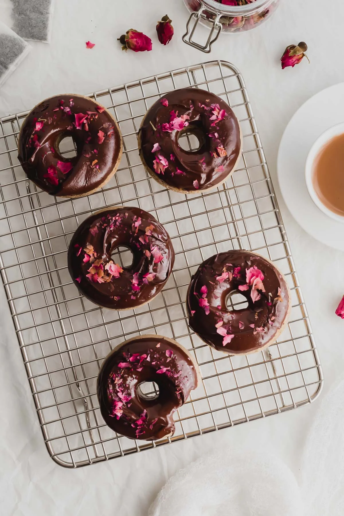 Earl Grey cake doughnuts with chocolate glaze and edible rose petals.
