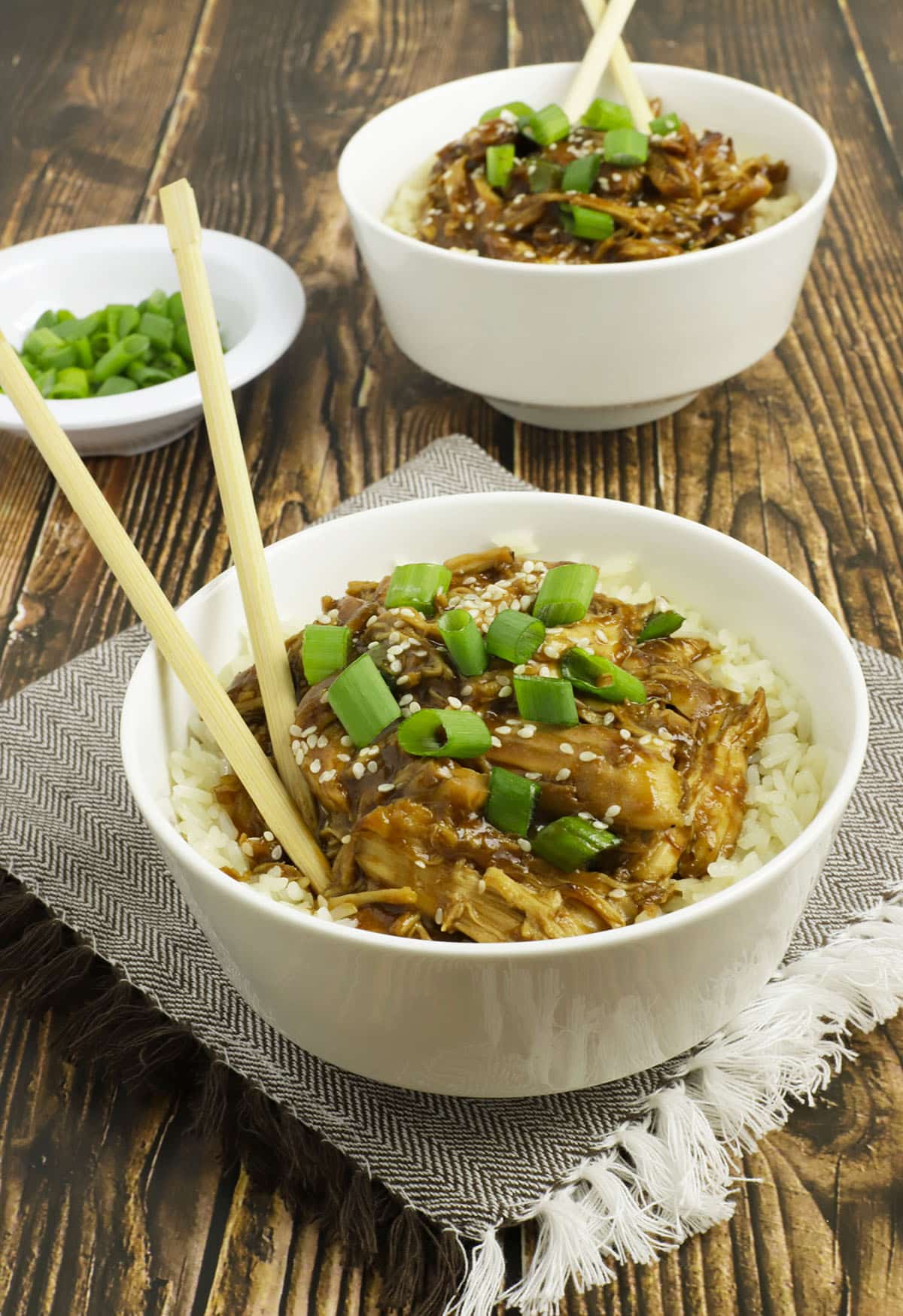 Garlic honey chicken crockpot recipe served over rice in white bowls.