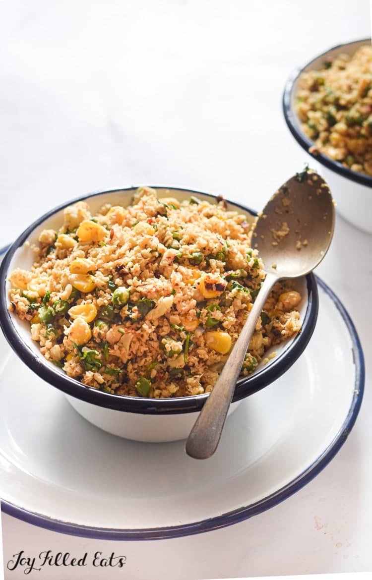 Mediterranean cauliflower rice with a big spoon in a bowl.