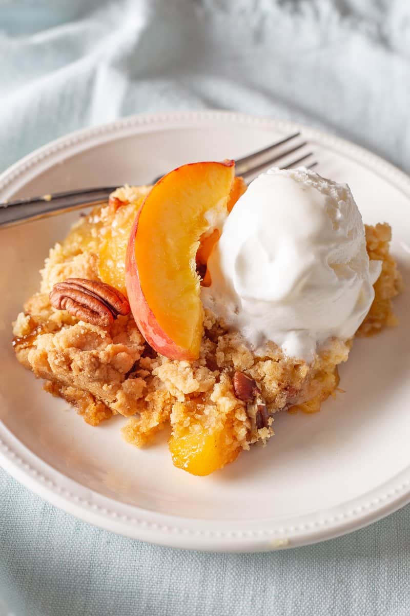 Easy fresh peach dump cake on a white plate.