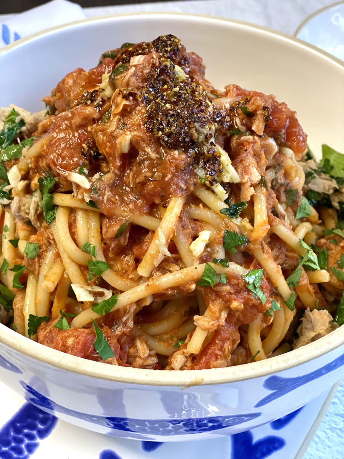 Tuna ragu with bucatini inside a white bowl.