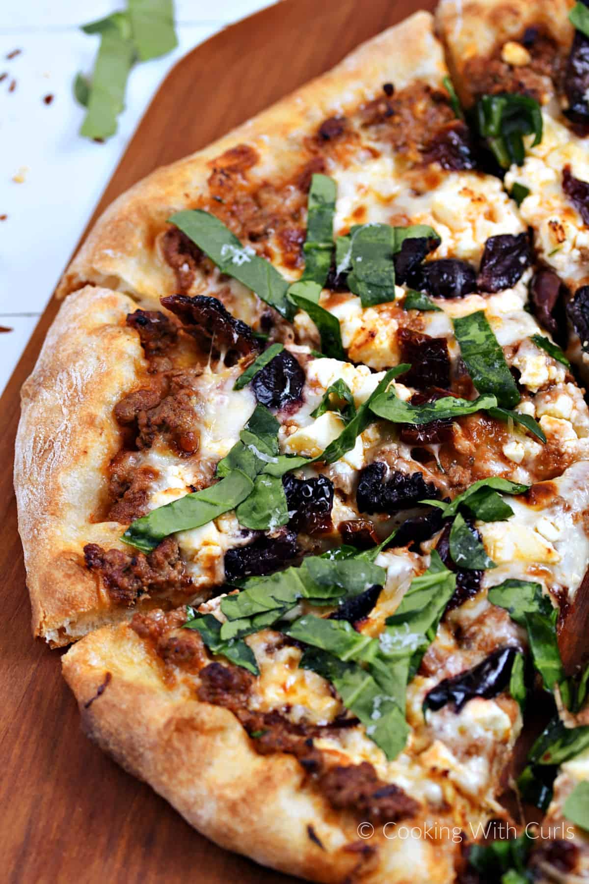 Mediterranean lamb pizza on a cutting board.