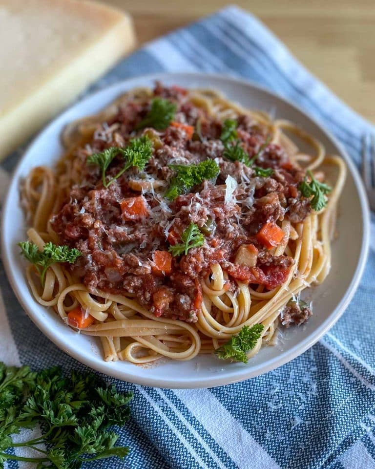 Linguine bolognese with veggies on a plate.