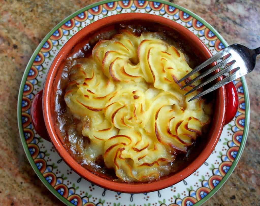 Shepherd's pie in a bowl atop a decorative plate.