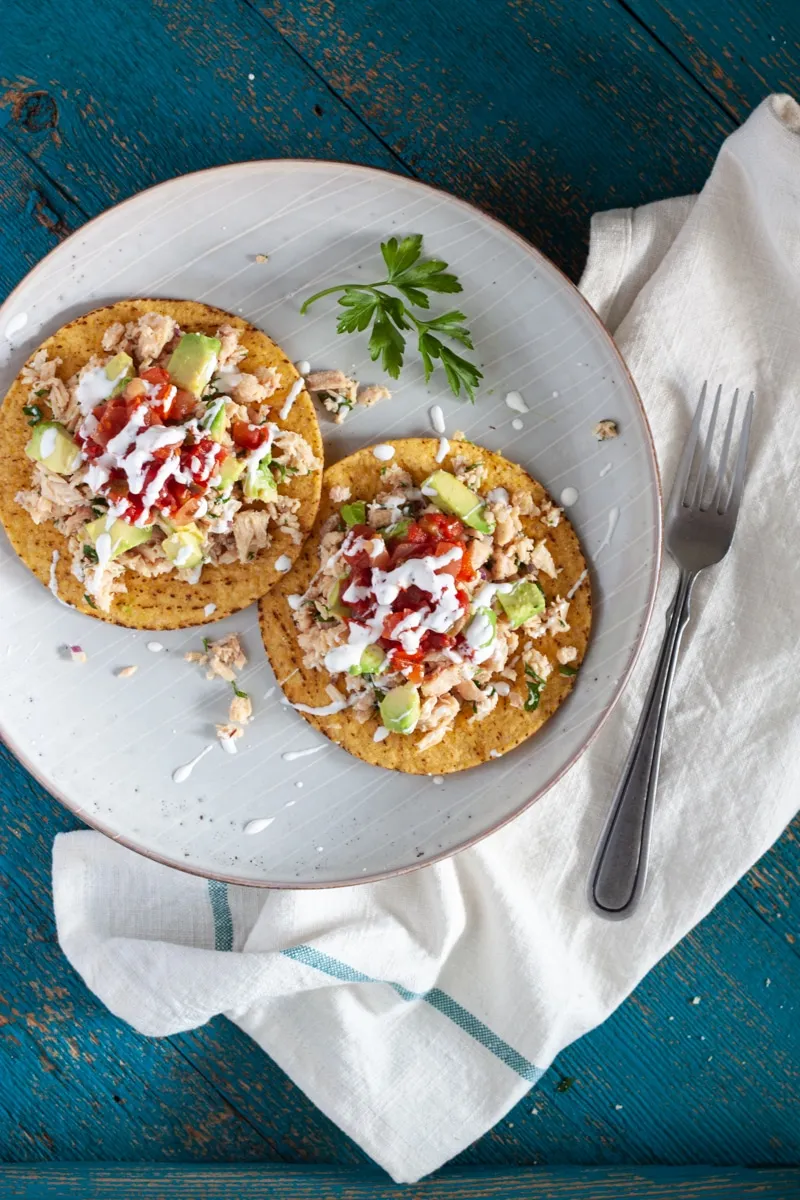 Tuna salad with avocado on a crispy tostada.