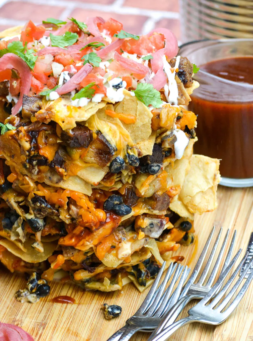 Pile of trash can nachos with loads of toppings.