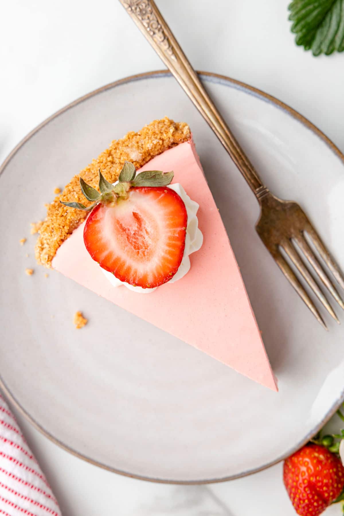 Strawberry Jello pie on a plate with a fork.