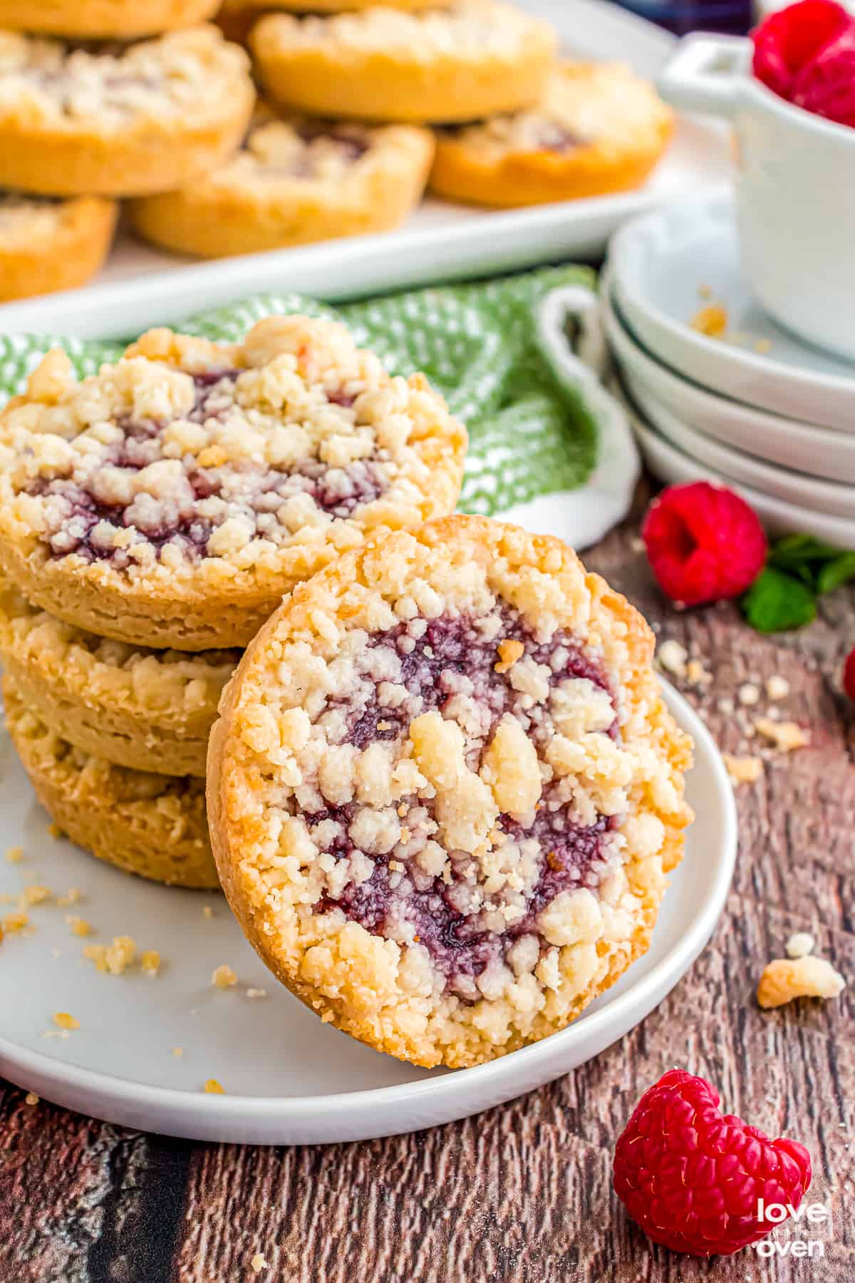 Stack of raspberry crumble cookies on a white plate.