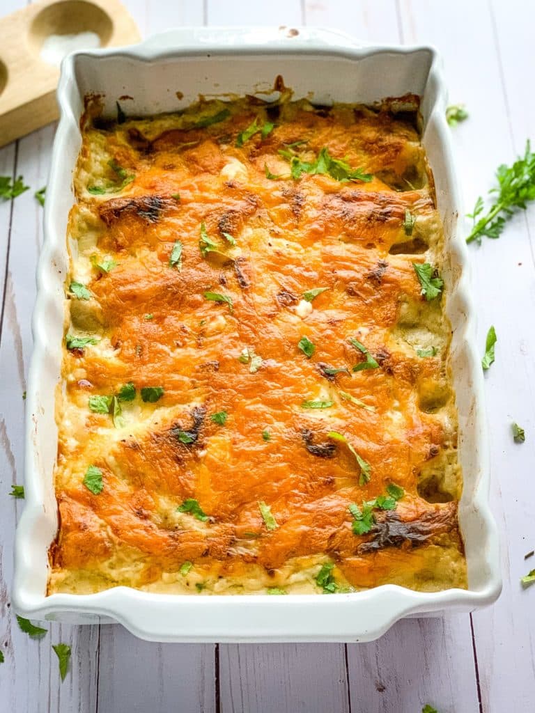 Creamy chicken enchiladas in a square baking dish.