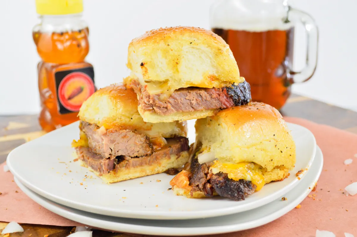 Stack of hot honey brisket sliders on a white plate.