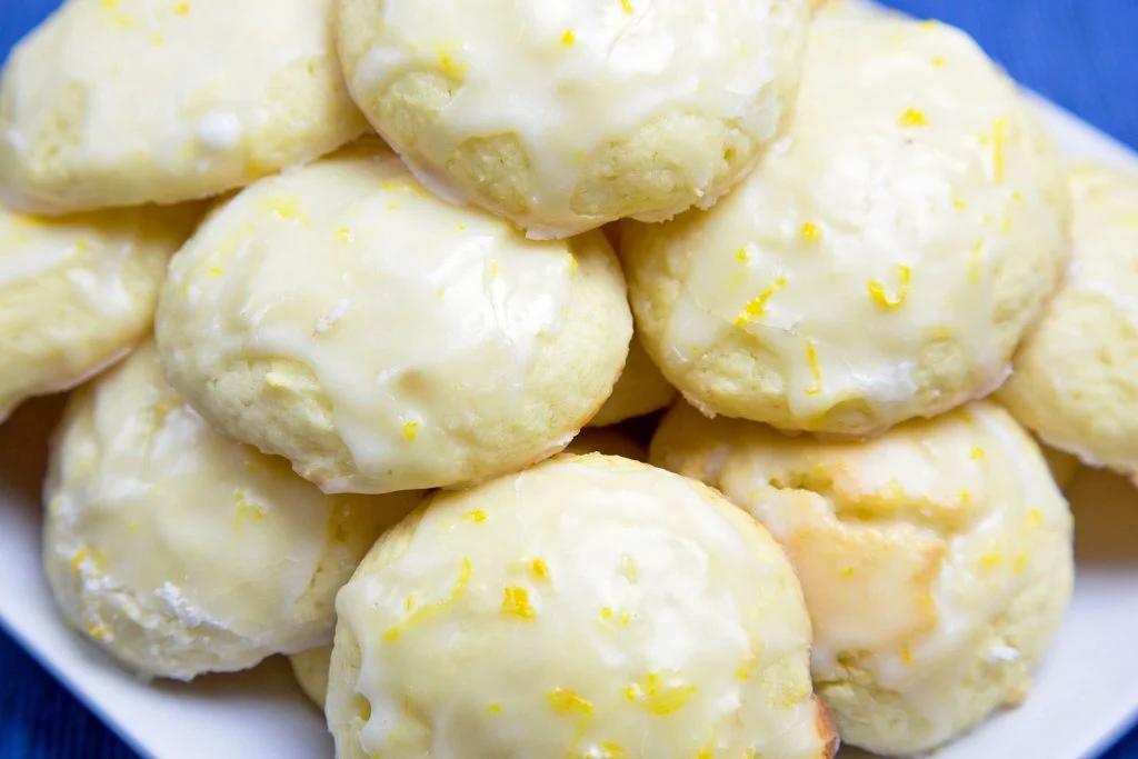 Lemon ricotta cookies piled on a white plate.