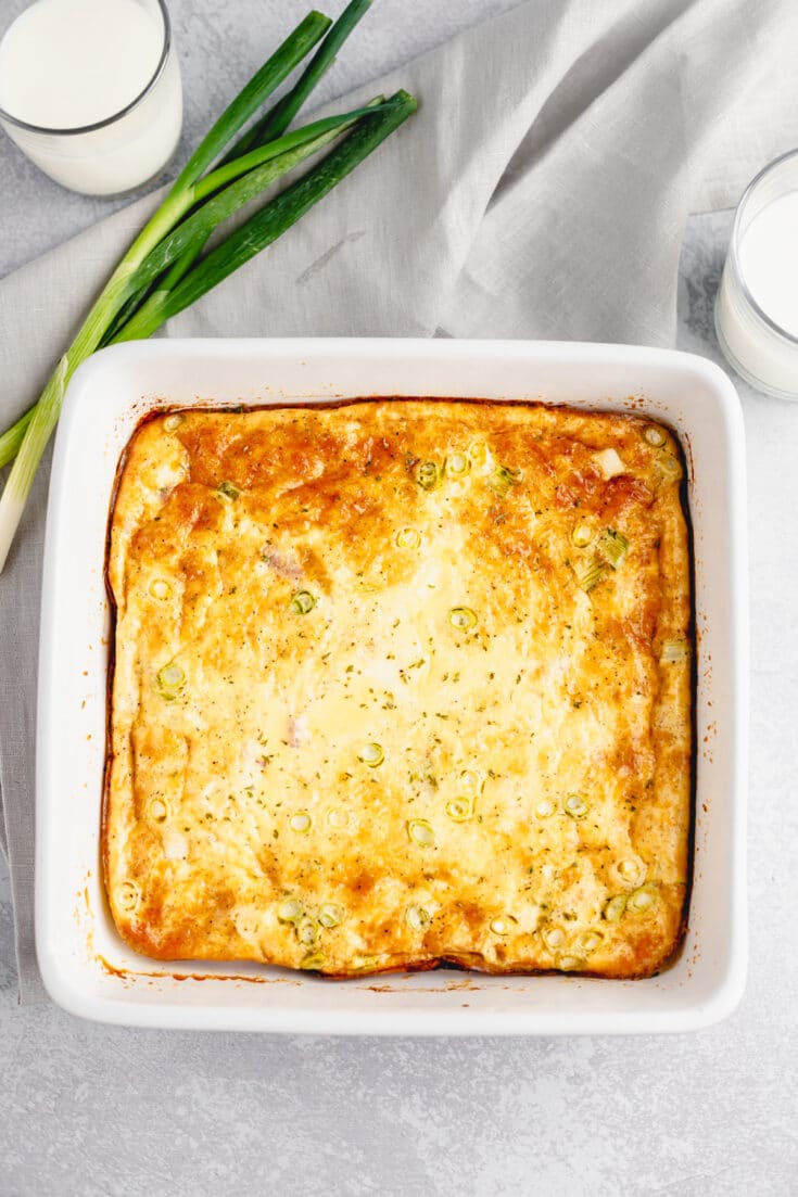 Baked ham and cheese omelet in a white baking dish.