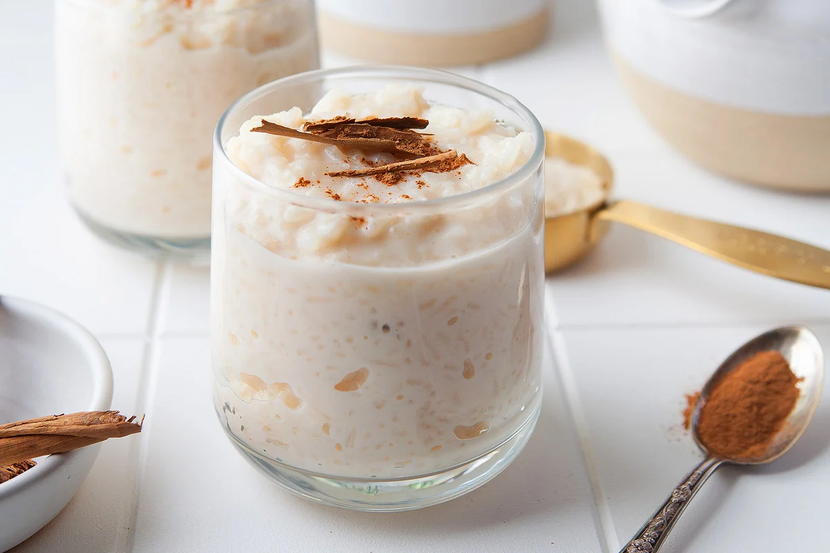 Mexican rice pudding in a glass cup with cinnamon on top.