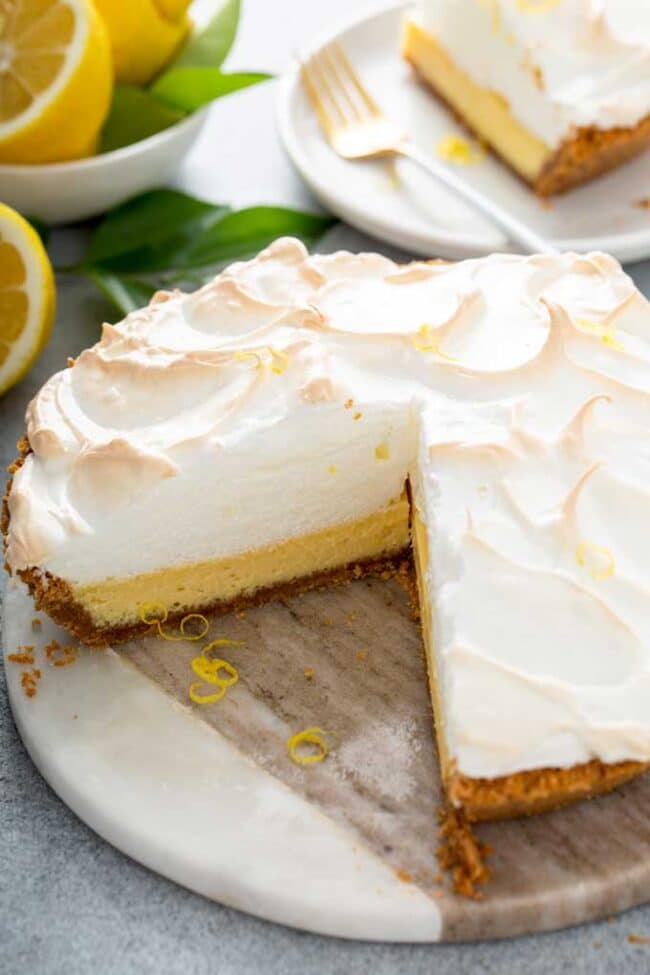 Creamy lemon meringue pie with slice removed.