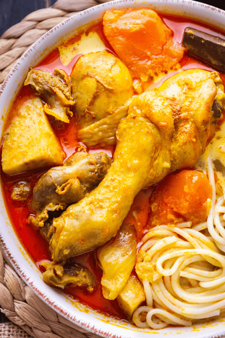 Vietnamese chicken curry with noodles, onion, and carrots in a bowl.