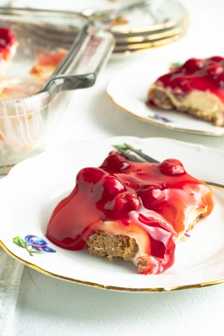 Slice of easy no bake cherry cheesecake on a decorative plate.