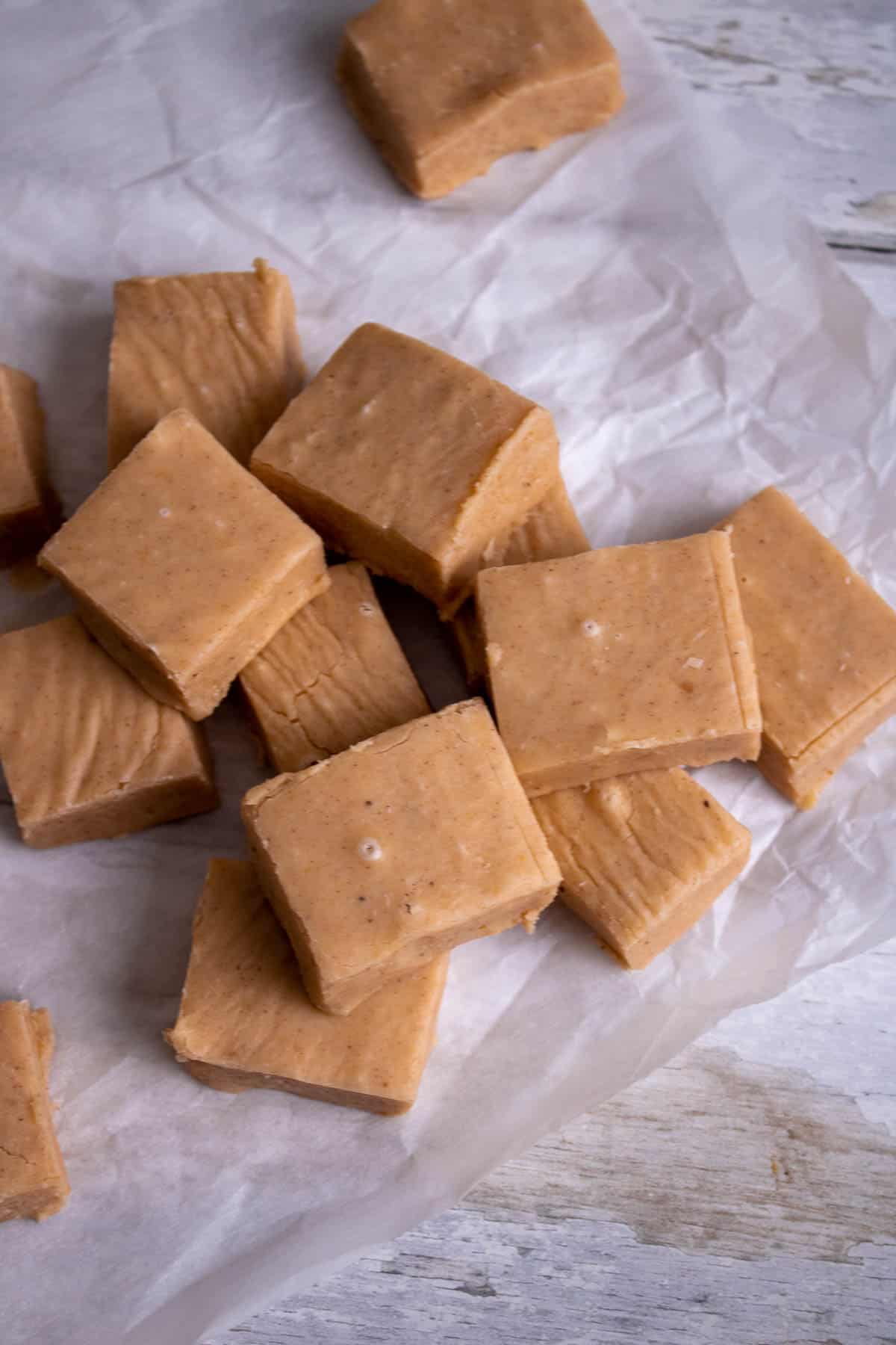 Pumpkin fudge pieces on a parchment paper.