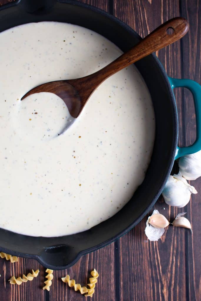 Homemade garlic alfredo sauce in sauce pan.