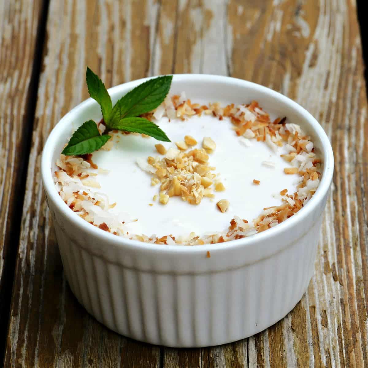 Vietnamese banana tapioca pudding in a white dessert bowl on a wooden background.