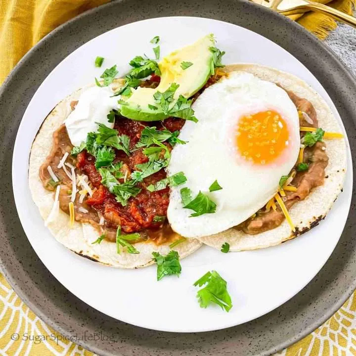 Spicy chipotle huevos rancheros on a white plate.
