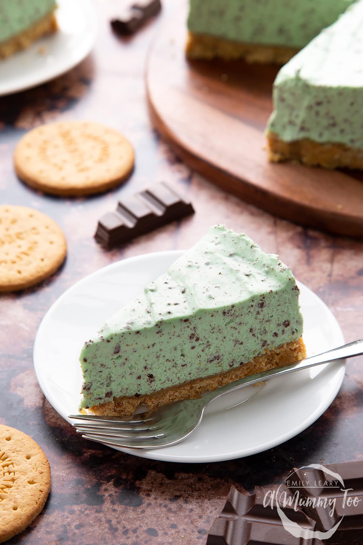 Slice of no bake mint chocolate chip cheesecake on a white plate with fork.