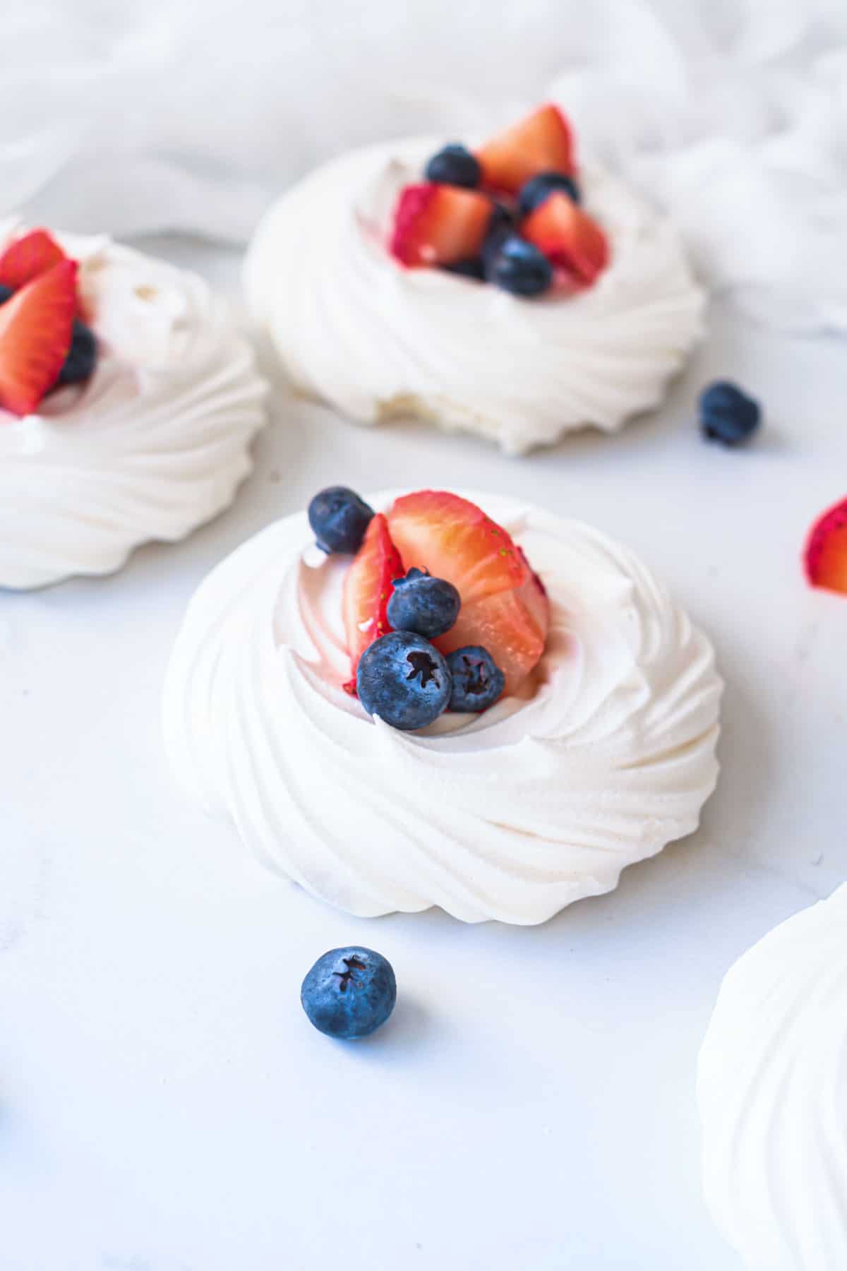 Red, white, and blue mini pavlovas arranged on a white background.