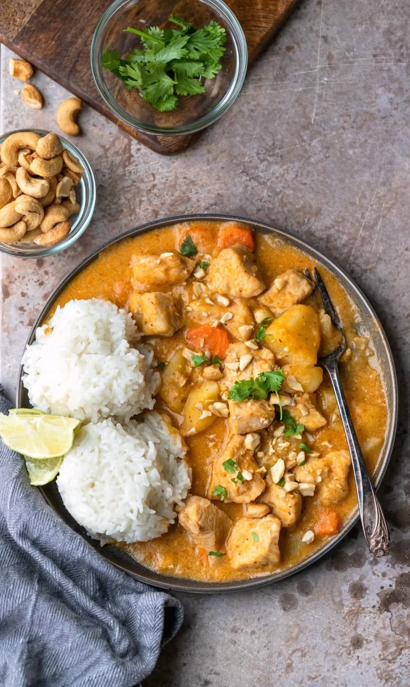 Bowl full of chicken massaman curry and two scoops of white rice.