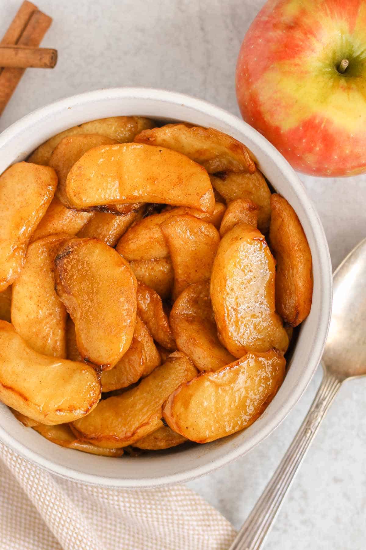 Air fryer apples in a white bowl.